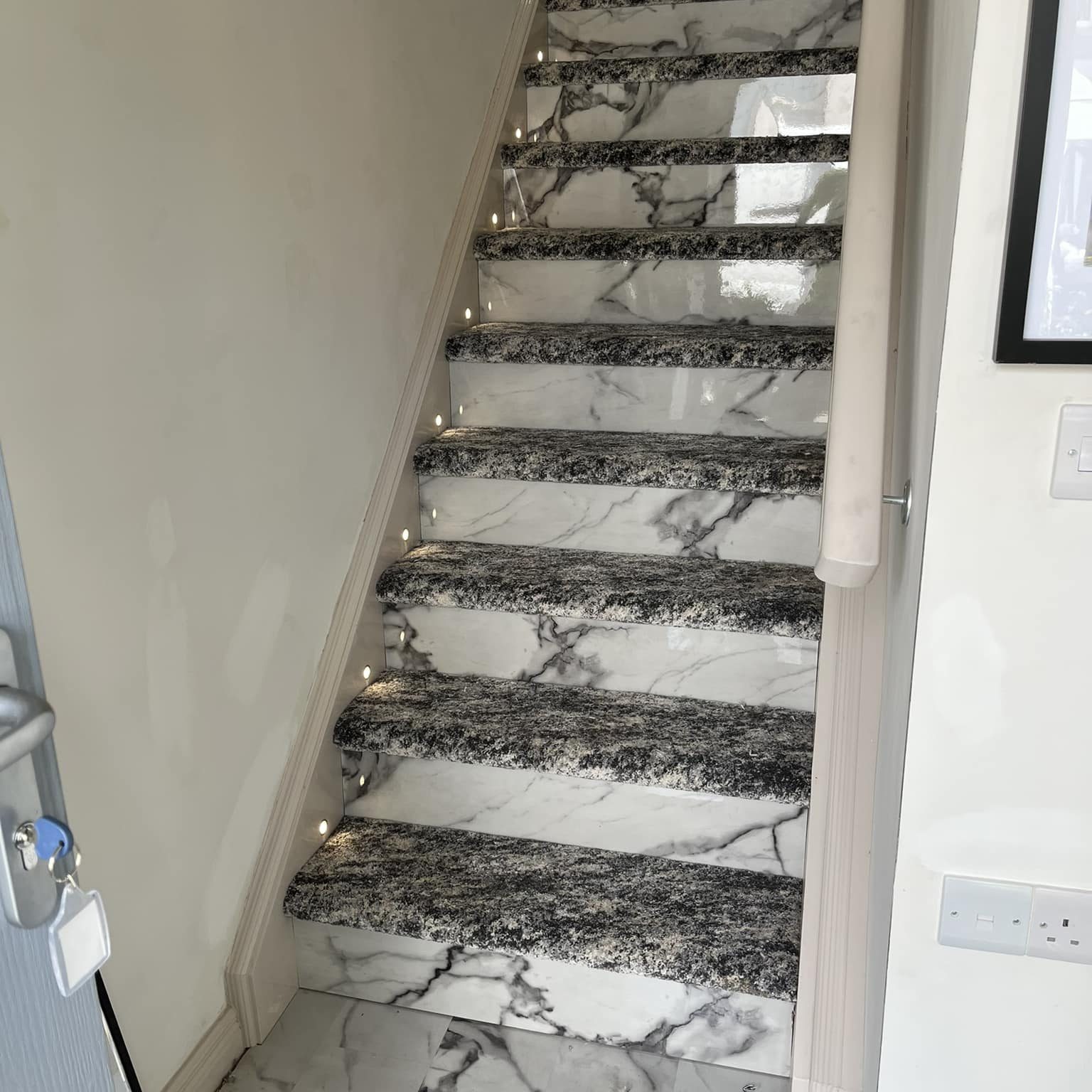 Marble effect laminate floor on stairs with grey carpet